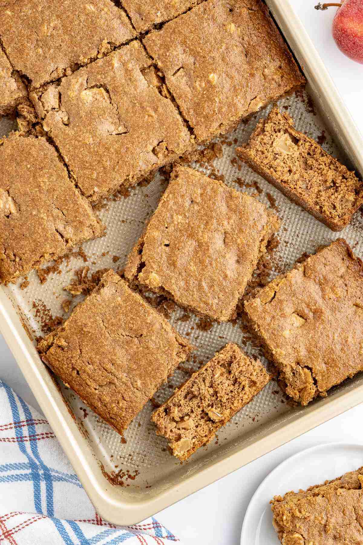 a cake pan with cut slices of apple oatmeal cake seen from overhead