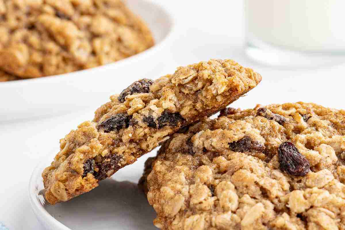 oatmeal raisin cookies on small white plate with one cookie showing bite shot