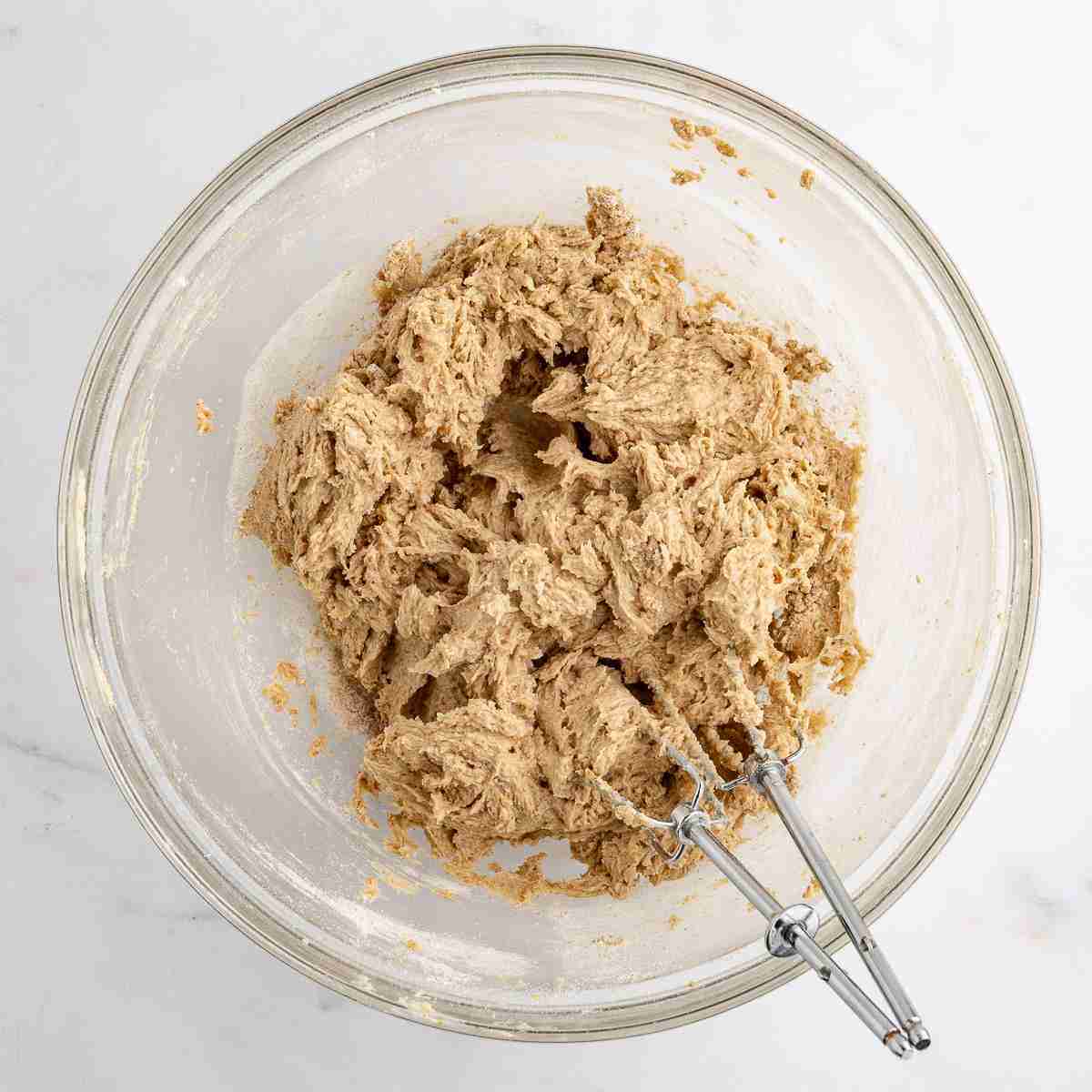 mixing bowl showing oatmeal raisin cookie dough after adding flour