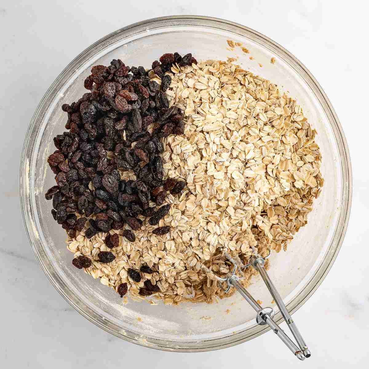 mixing bowl showing oats and raisins added to dough