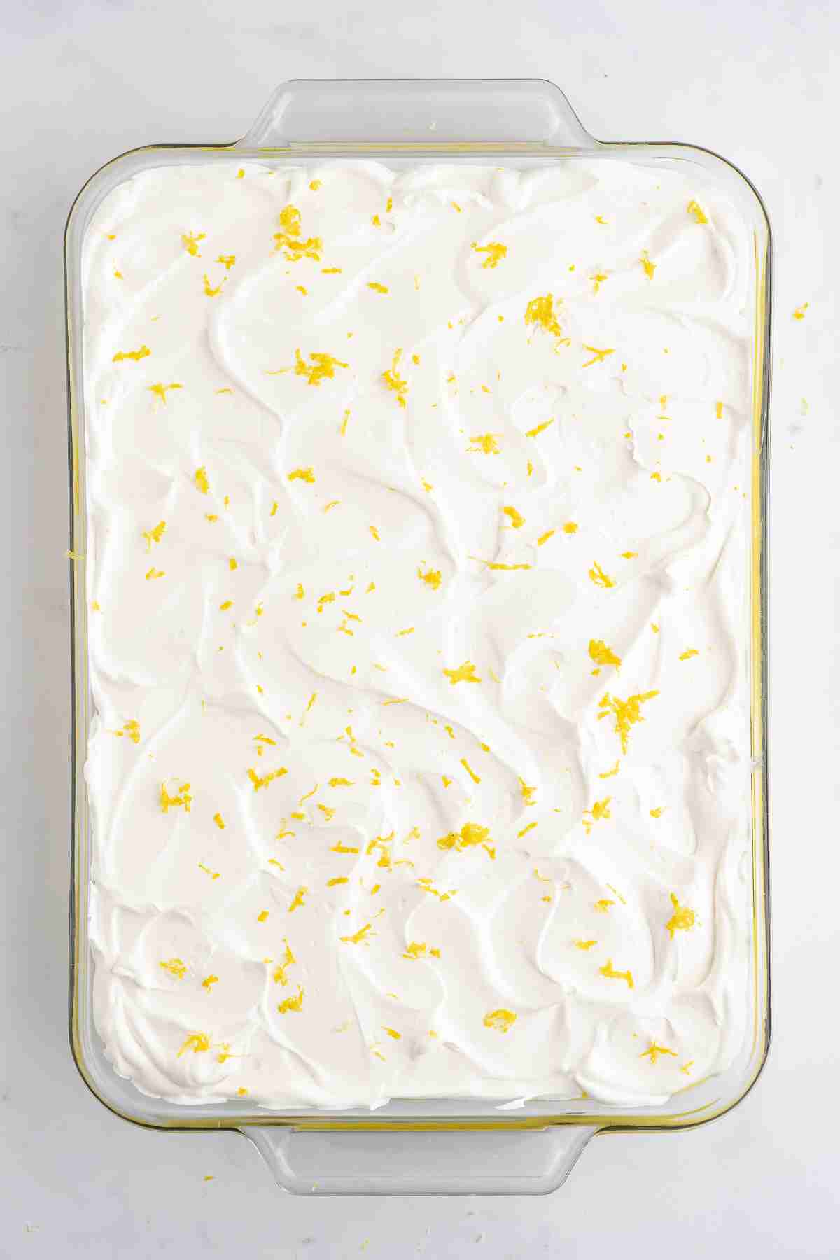 finished lemon lush dessert in pan sprinkled with lemon zest