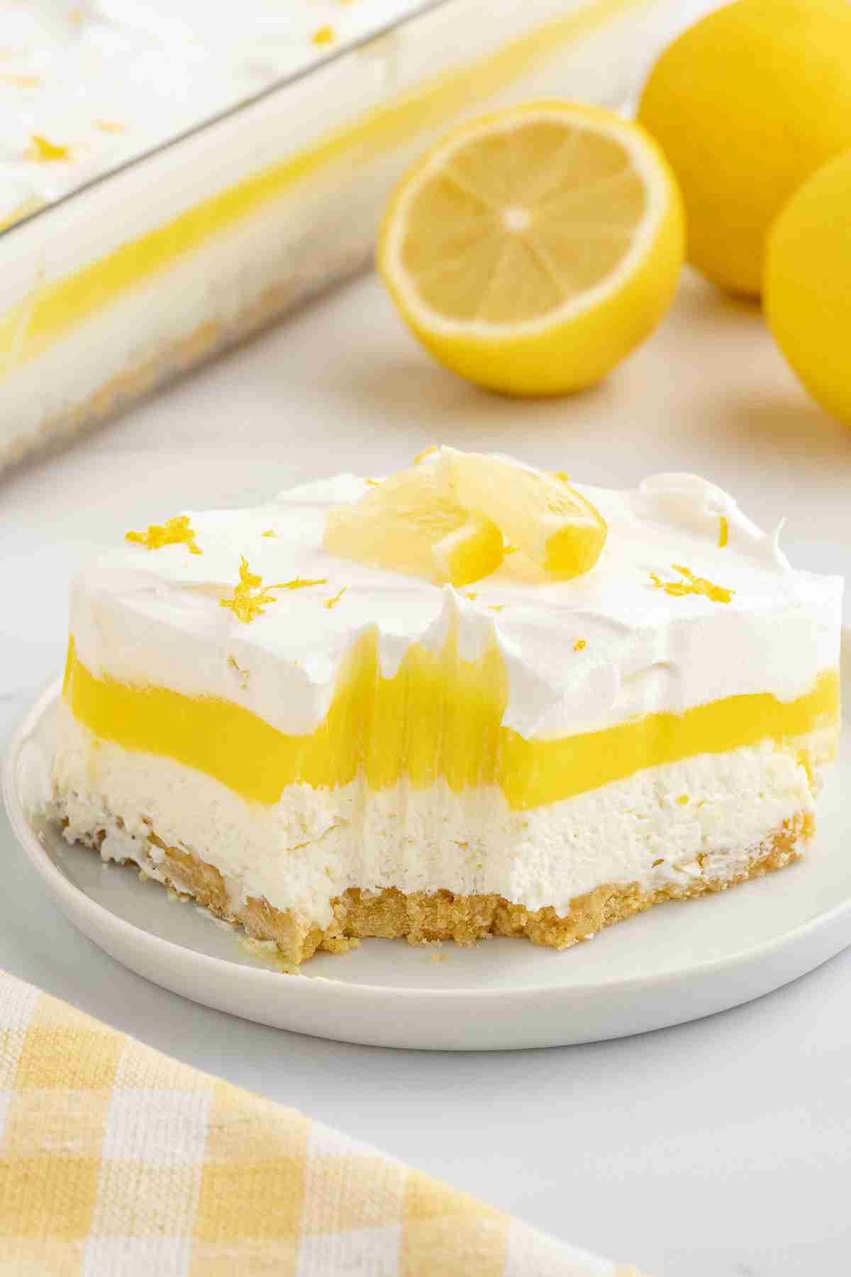 single serving of lemon lush on white plate with bite taken out showing inside texture