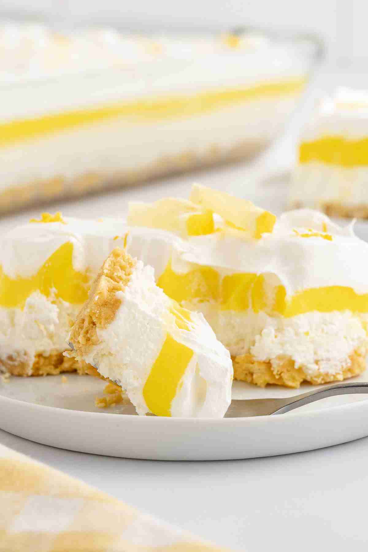 since serving of lemon lush dessert with closeup of bite on fork