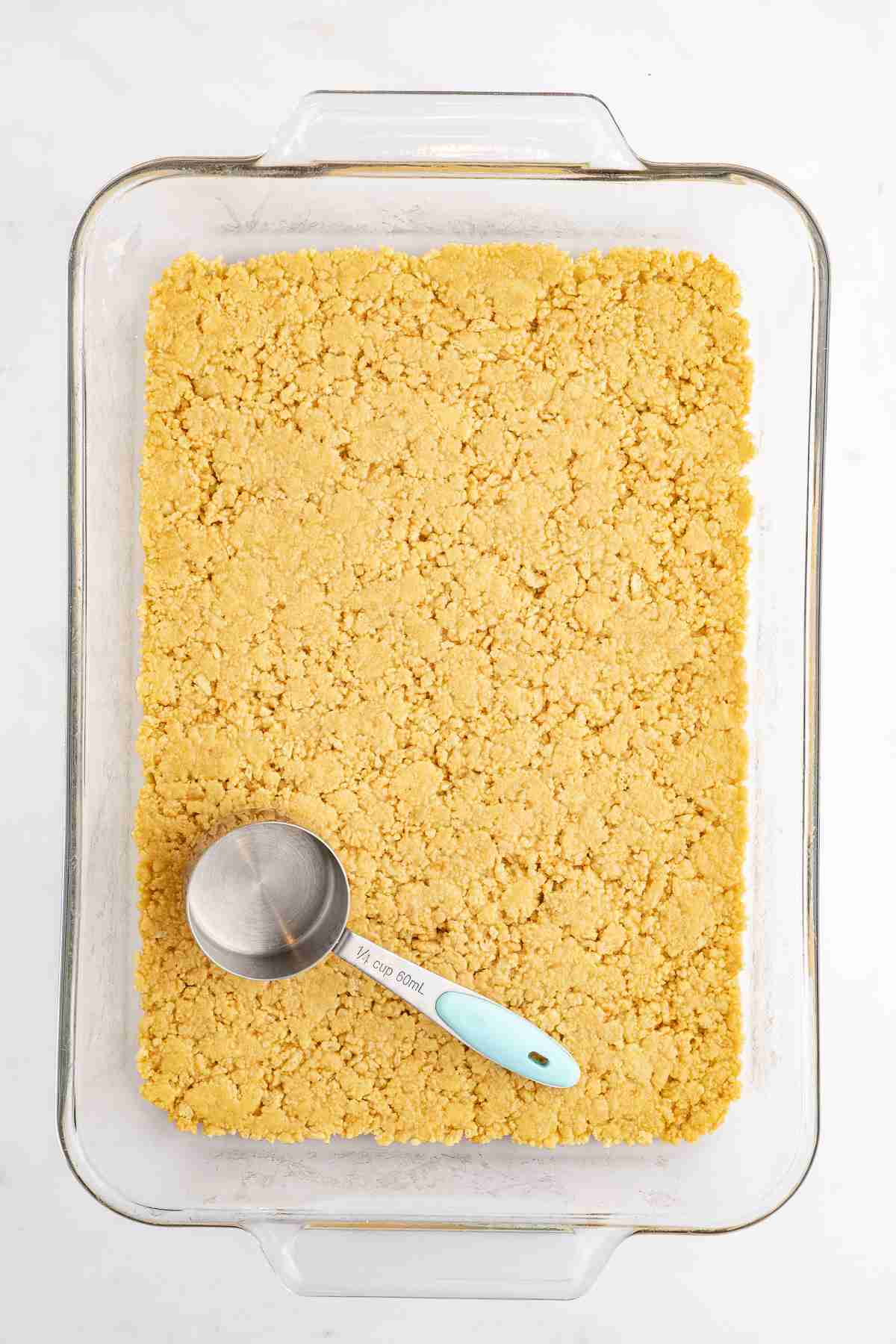 9 x 13 pan showing pressing down the crust for lemon lush dessert