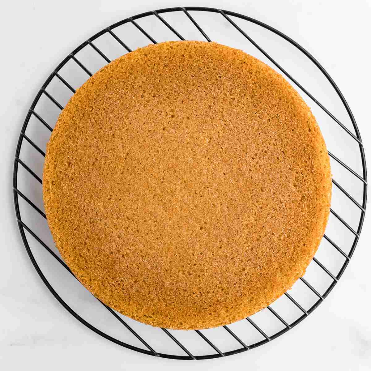 a baked layer cake on cooling rack after using cake release