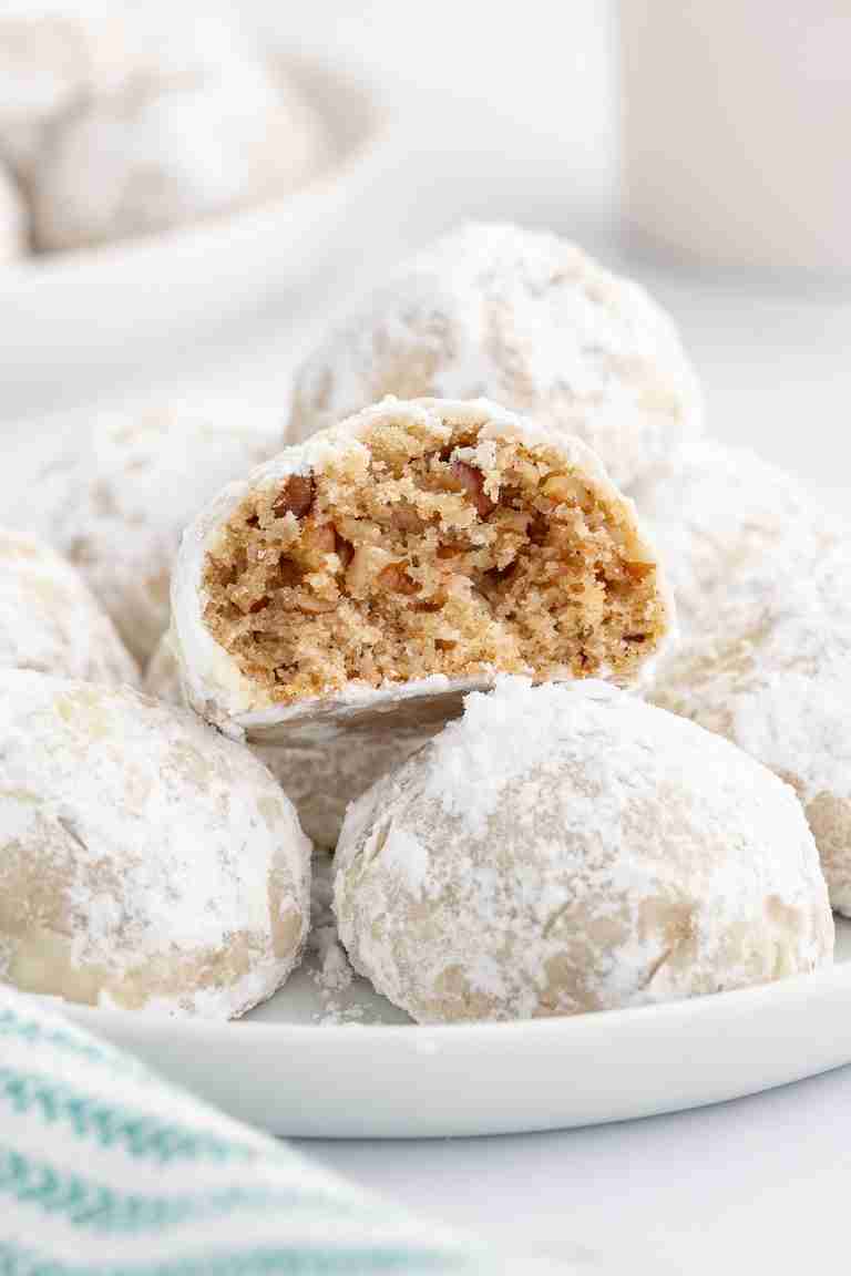 a plate of fresh milled mexican wedding cookies with one cookie showing inside texture