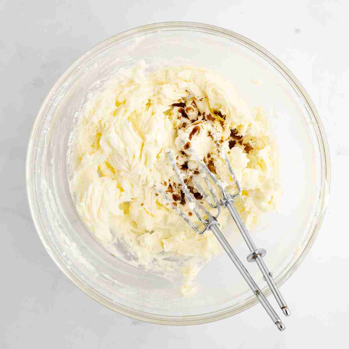 mixing bowl showing creamed butter and sugar with vanilla added