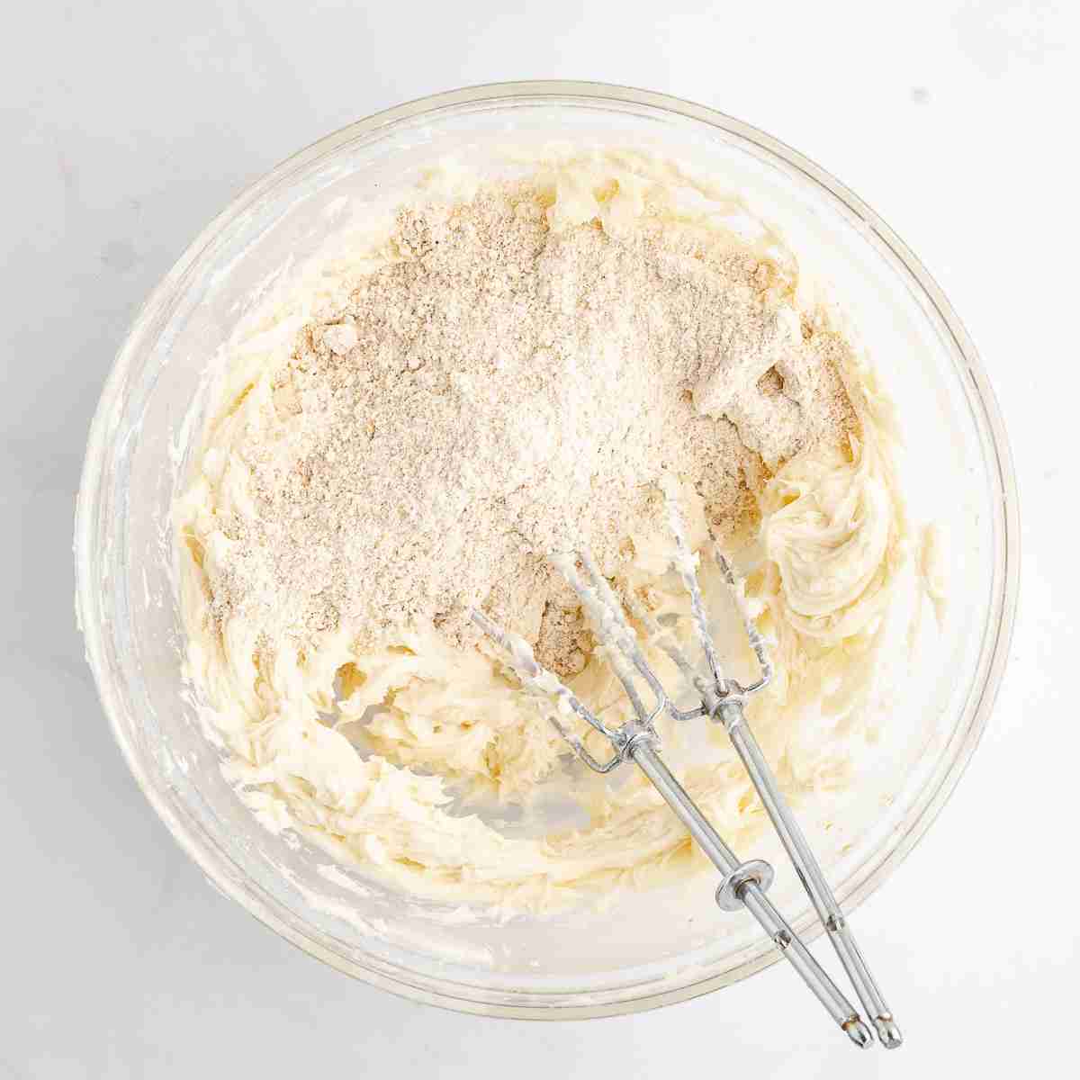 mixing bowl showing flour added to creamed butter and sugar 
