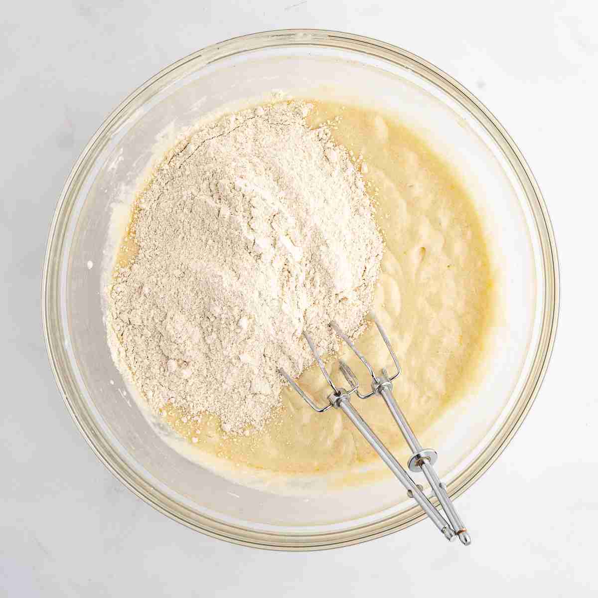 mixing bowl showing first part of flour added to fresh milled cake batter