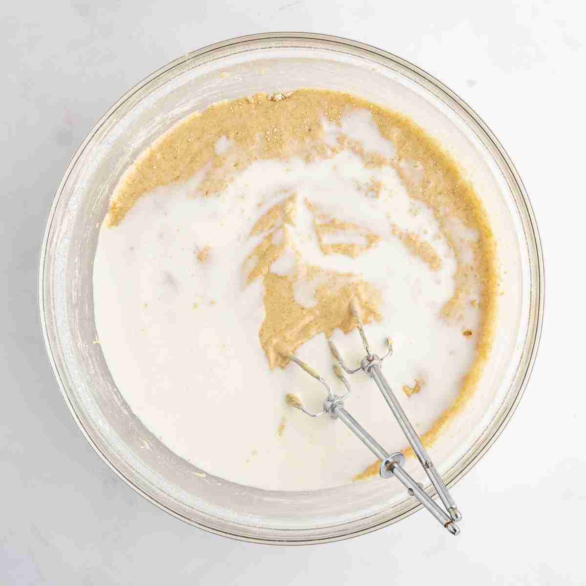 mixing bowl showing milk added to fresh milled cake batter