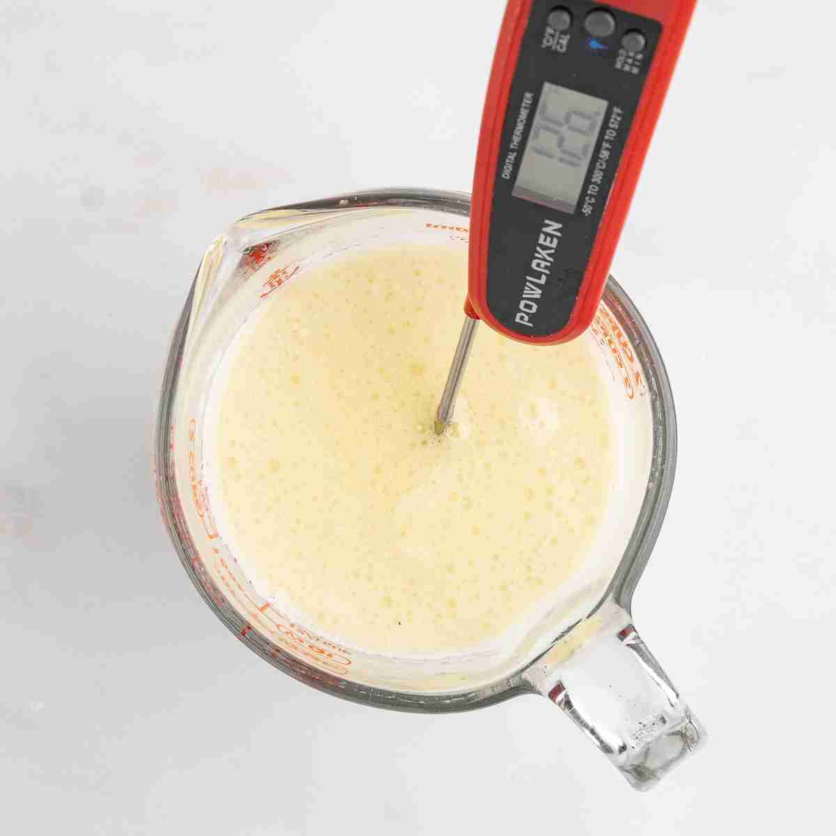 measuring cup with milk oil and water for fresh milled English muffin toasting bread